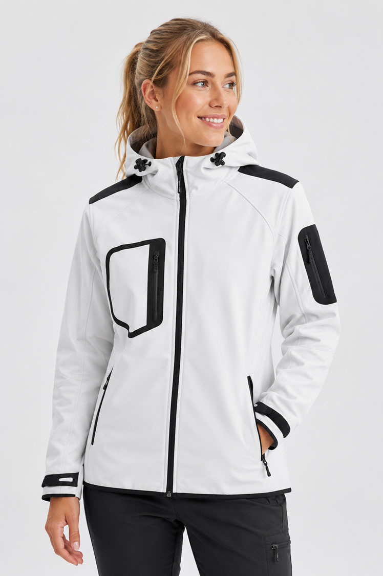 Chaqueta softshell técnica de mujer blanca con capucha, tejido de tres capas y múltiples bolsillos con cremallera, presentada por una modelo en estudio.